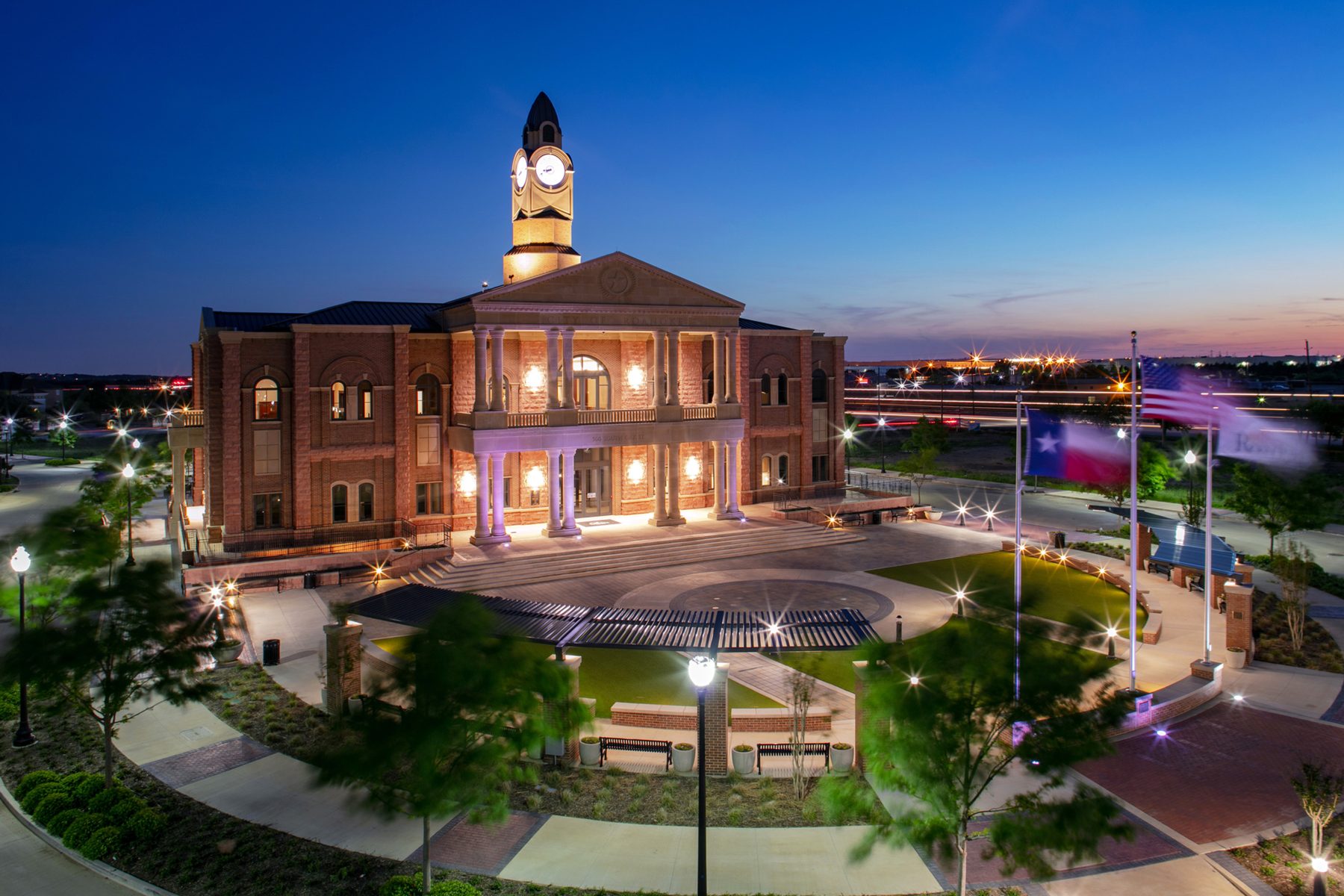 Roanoke City Hall at dusk with its lit clock tower, plaza and pergola